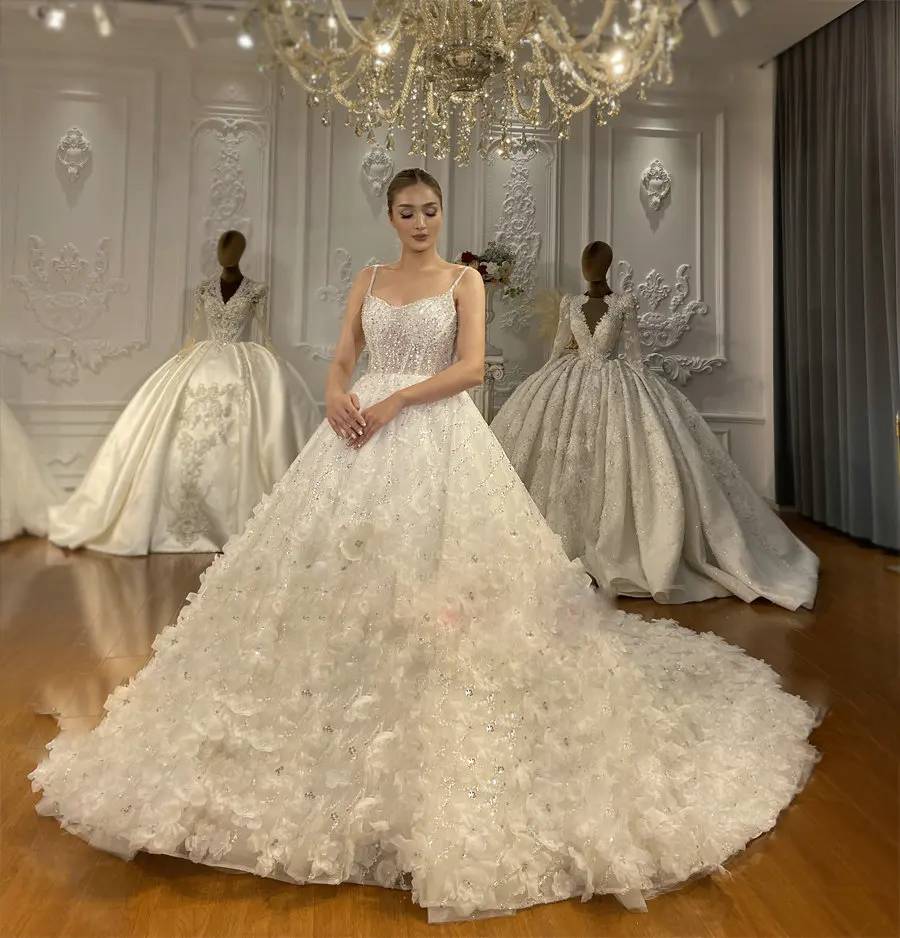 Glamorous sleeveless A-line bridal gown with delicate spaghetti straps and a sparkly tulle skirt adorned with 3D floral appliqués.