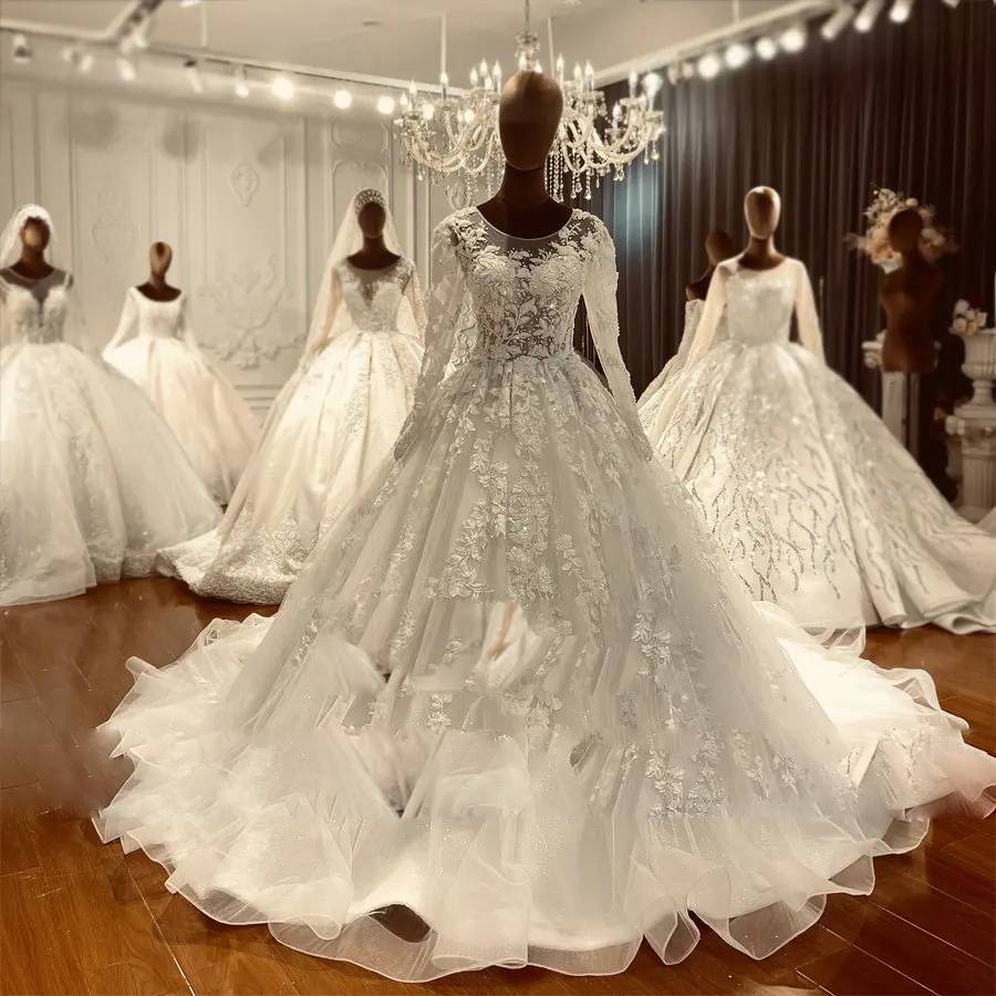 Frontal view of a lightweight flowy wedding dress with a detailed lace bodice and a cathedral-length shimmering tulle skirt.