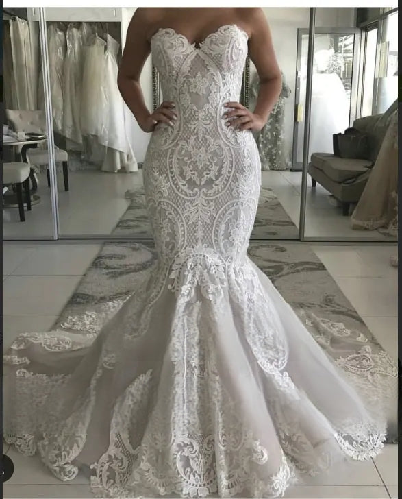 Close-up front view of an intricate floral lace mermaid bridal dress with a sweetheart neckline, highlighting the fitted bodice and scalloped lace detailing.
