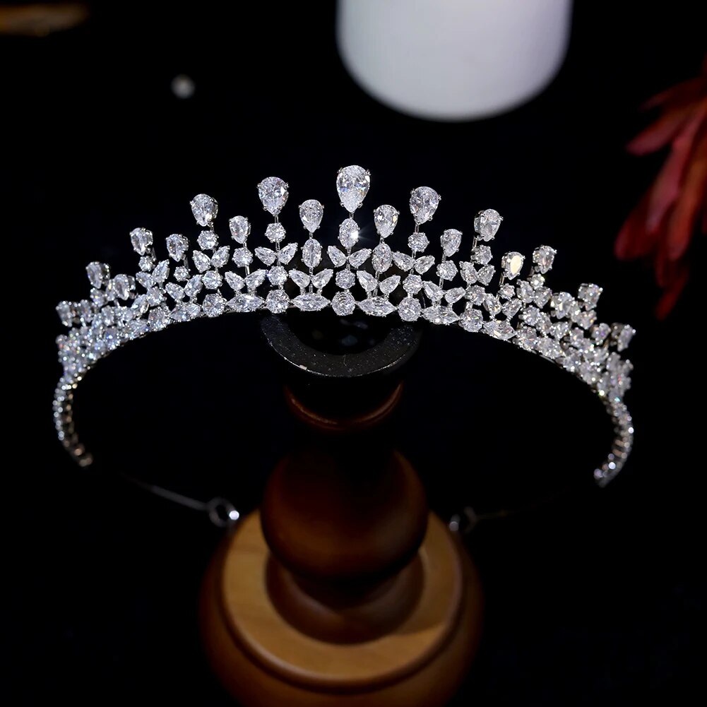 Product view of an open-back silver bridal party tiara headband featuring a large central teardrop crystal accented by staggered pave rhinestone rows.
