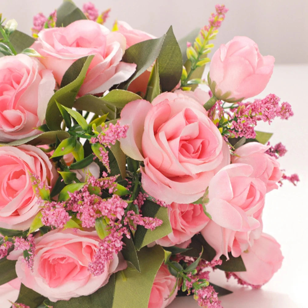 Detailed macro view of faux pink silk roses and delicate purple accent flowers highlighting the realistic petals of the wedding bouquet.
