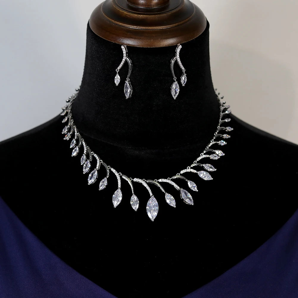 Symmetrical front view of a premium silver round necklace and matching earrings set presented on a velvet jewelry mount.
