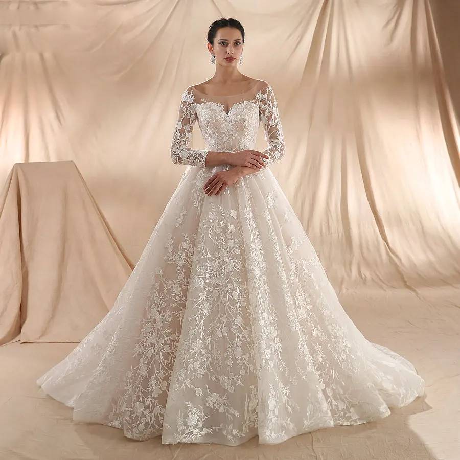 Full-length front view of a new arrival champagne bridal gown with a sweetheart illusion neck and a voluminous, flowing A-line skirt.