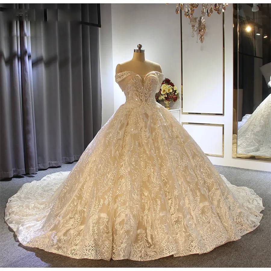 Front view of an elegant off-the-shoulder champagne ball gown princess wedding dress with heavy lace embellishments.
