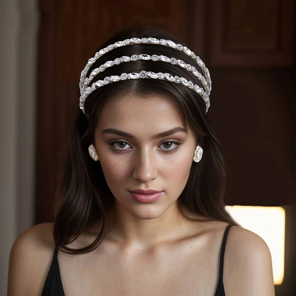 A front-facing portrait of a model showcasing the multi-tier rhinestone crystal bridal headband accessory with a classic hairstyle.
