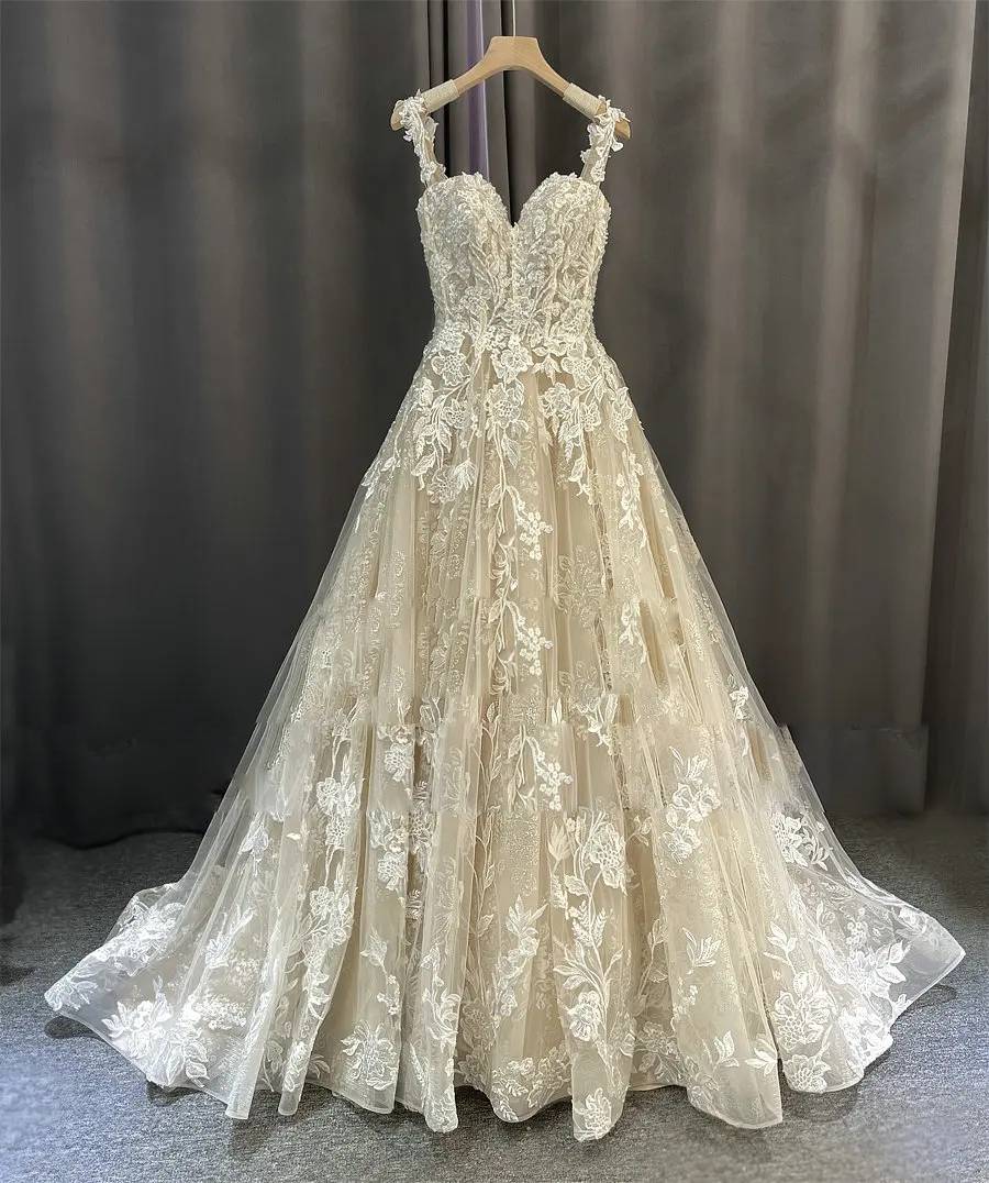 Elegant romantic beach style wedding dress showcasing the delicate lace bodice and flowing skirt on a hanger.