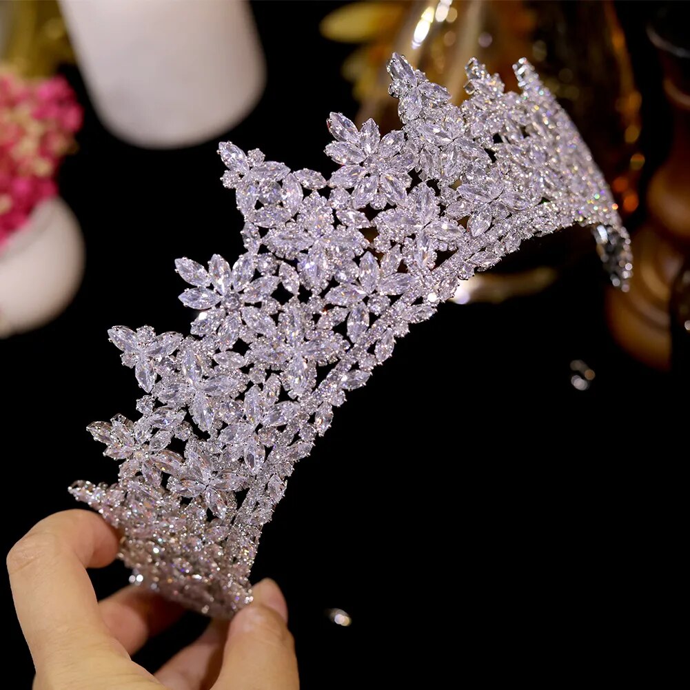 Handheld side-profile view of the premium silver bridal diadem crown emphasizing its curved structural framework and high-density gemstone clusters.