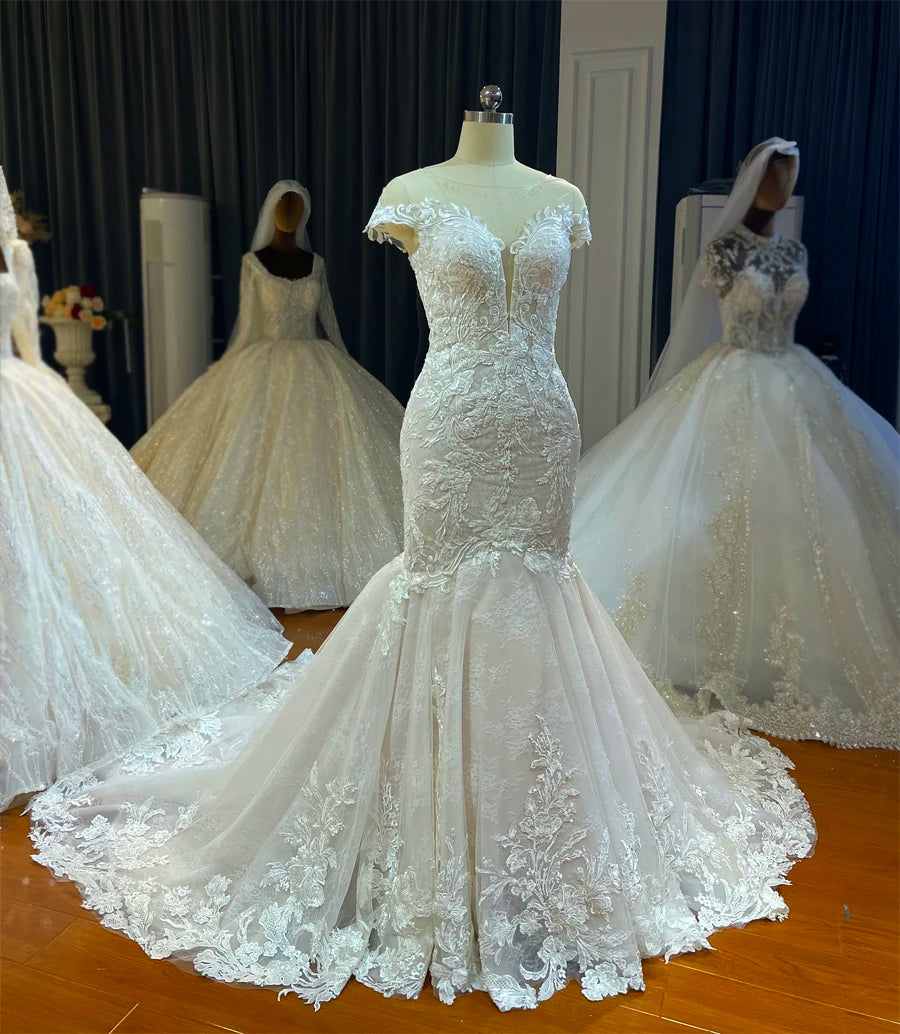 An angled front view of the light flowy mermaid wedding dress displayed on a mannequin in a bridal showroom setting.