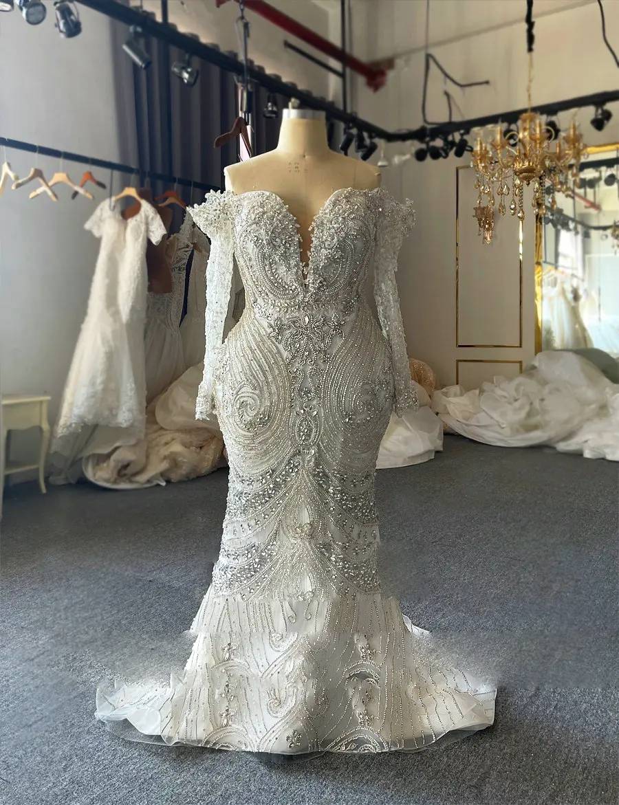 Rear profile of a luxury bridal gown highlighting the extraordinary length of the shimmering cathedral train and the intricate beaded embroidery across the back.
