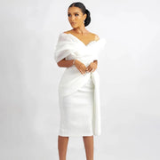 Modern off-the-shoulder white short wedding dress featuring an asymmetric draped organza overlay, a structured knee-length sheath silhouette, and delicate crystal beaded accents on an illusion neckline.