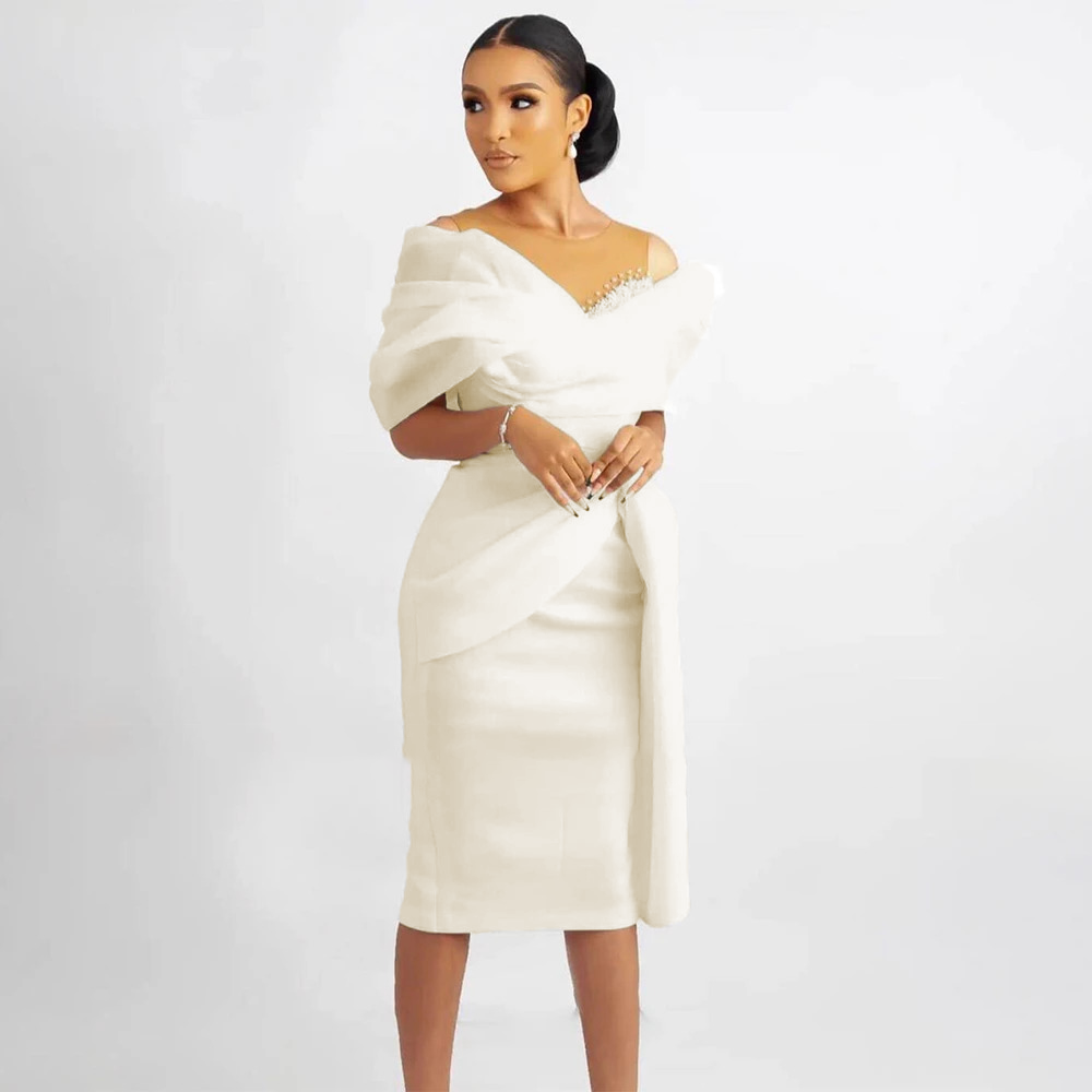 Sleek pure white knee-length bridal gown with an architectural off-shoulder drape and a fitted pencil skirt, perfect for a modern city hall wedding.