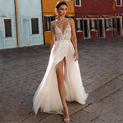A bride wearing a 2024 boho tulle wedding dress with a deep V-neck, intricate bodice detailing, and a high side split.