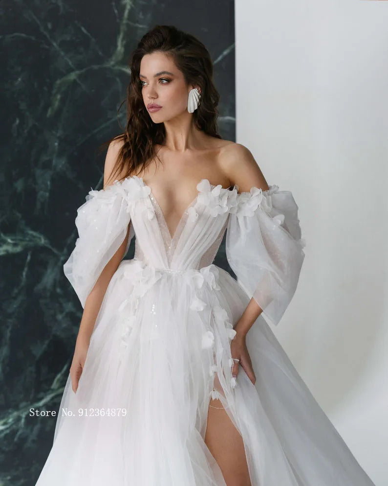 Close-up of a bridal gown showcasing the open back design, delicate 3D flower appliques, and stylish detachable puff sleeves.