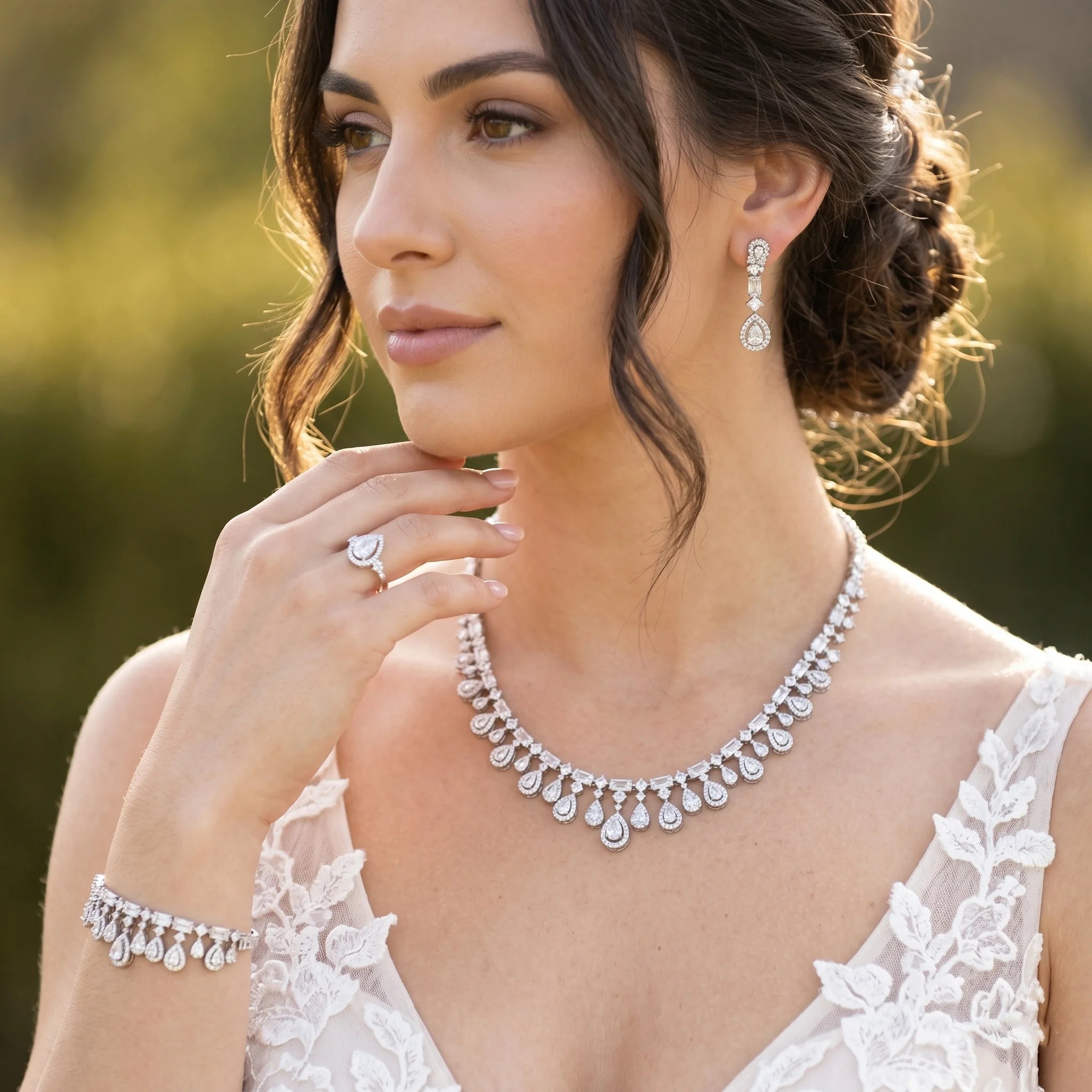 Model wearing a 4-piece cubic zirconia bridal wedding jewelry set featuring a halo teardrop fringe necklace and matching drop earrings.