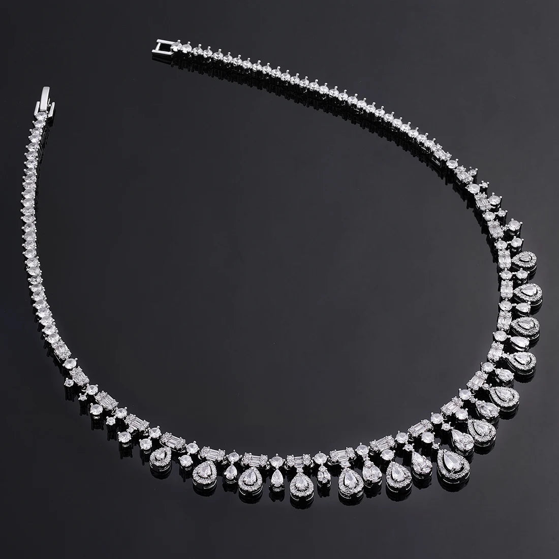 Close-up top-down view of a silver cubic zirconia wedding necklace band, highlighting the round crystal link chain and baguette settings.