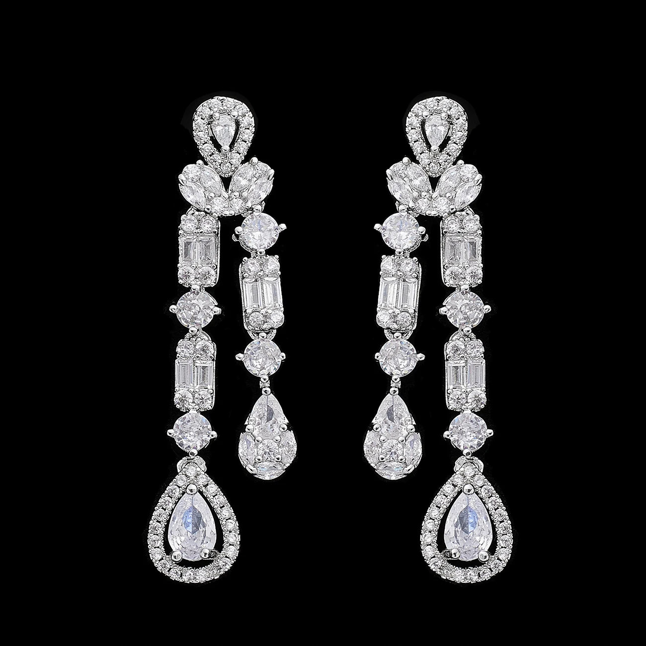 High-resolution close-up of geometric cubic zirconia bridal drop earrings featuring a unique multi-tier baguette and round crystal design on a black background.