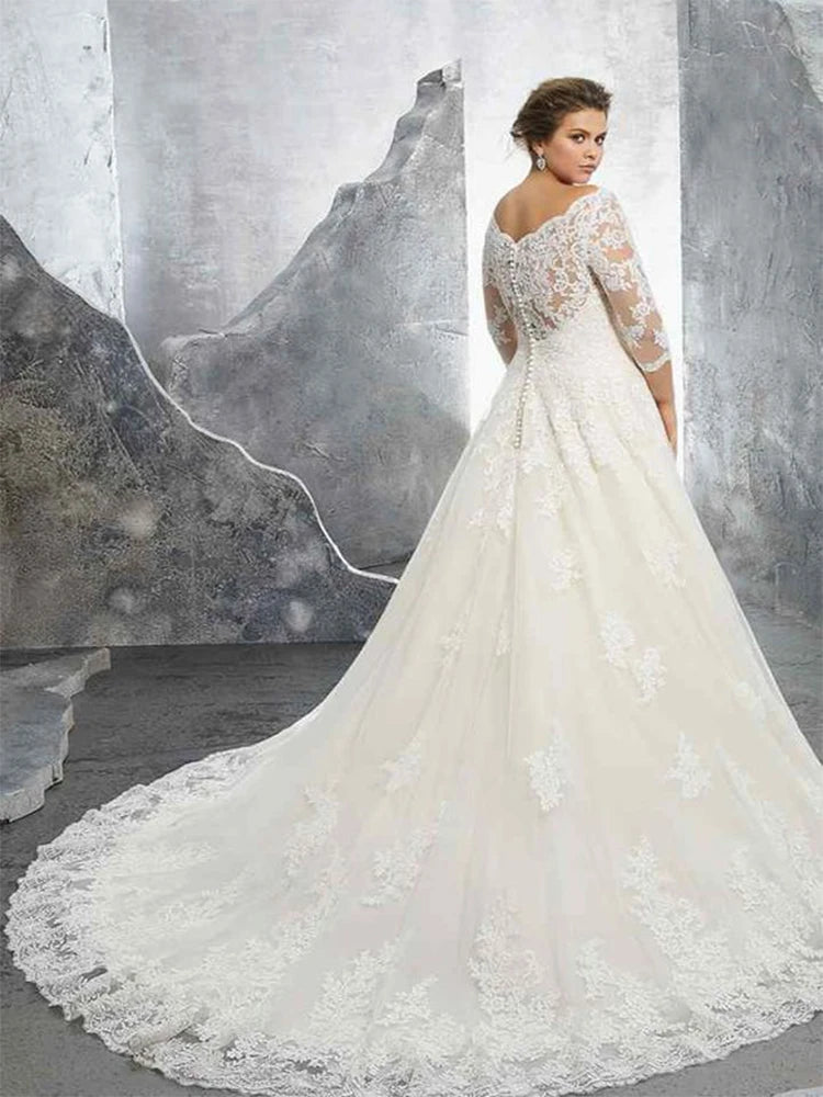 Back view of a stunning plus-size bridal gown with an off-shoulder lace design, featuring a long lace train and delicate button closure.