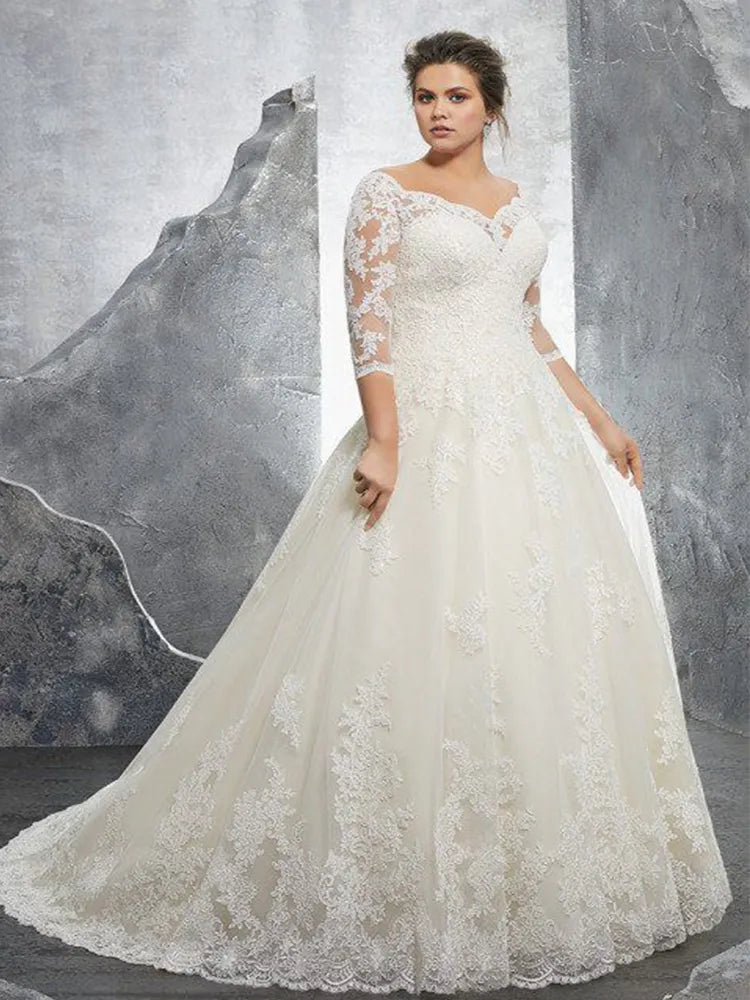 Front profile of a sophisticated plus-size A-line bridal gown showcasing a flattering off-shoulder lace neckline and bodice.