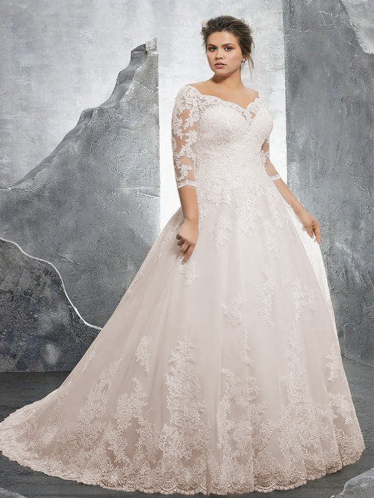 Detailed close-up of the exquisite lace and beaded appliques on a plus-size A-line bridal gown.