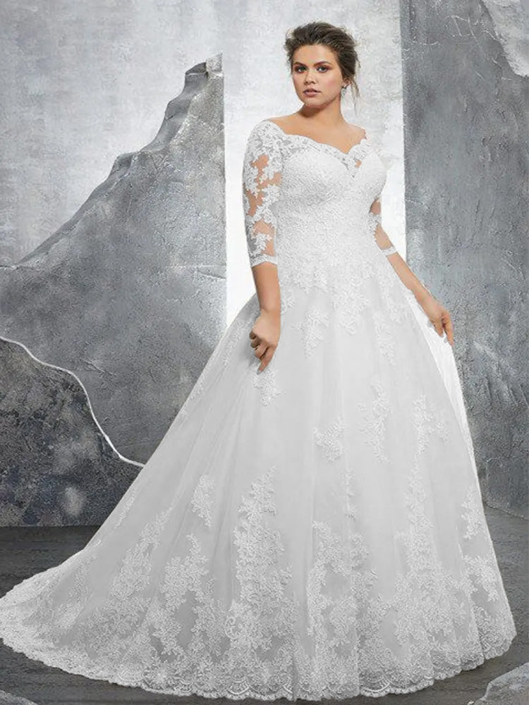 A plus-size A-line wedding dress with an off-shoulder neckline, showcased on a mannequin with a long, detailed lace train.