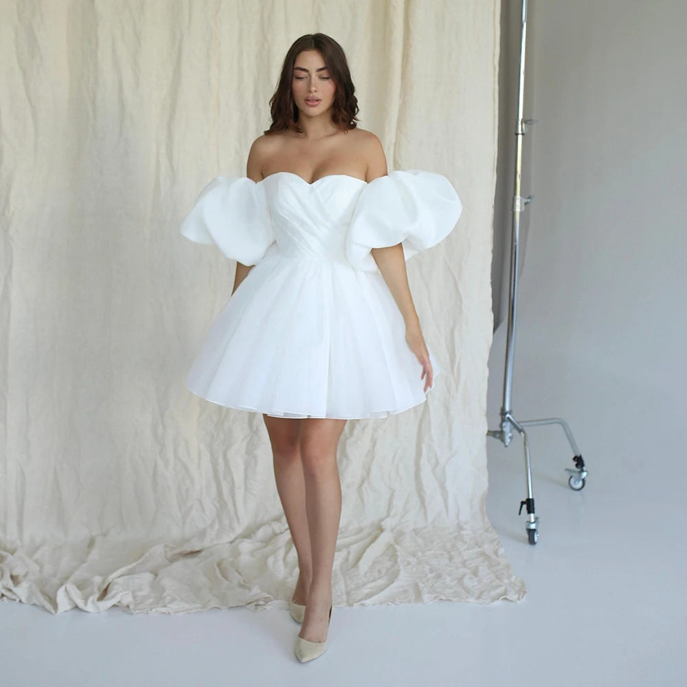 Crisp pure white organza mini wedding dress with detachable statement puffy sleeves, perfect for a contemporary bridal reception or civil ceremony.