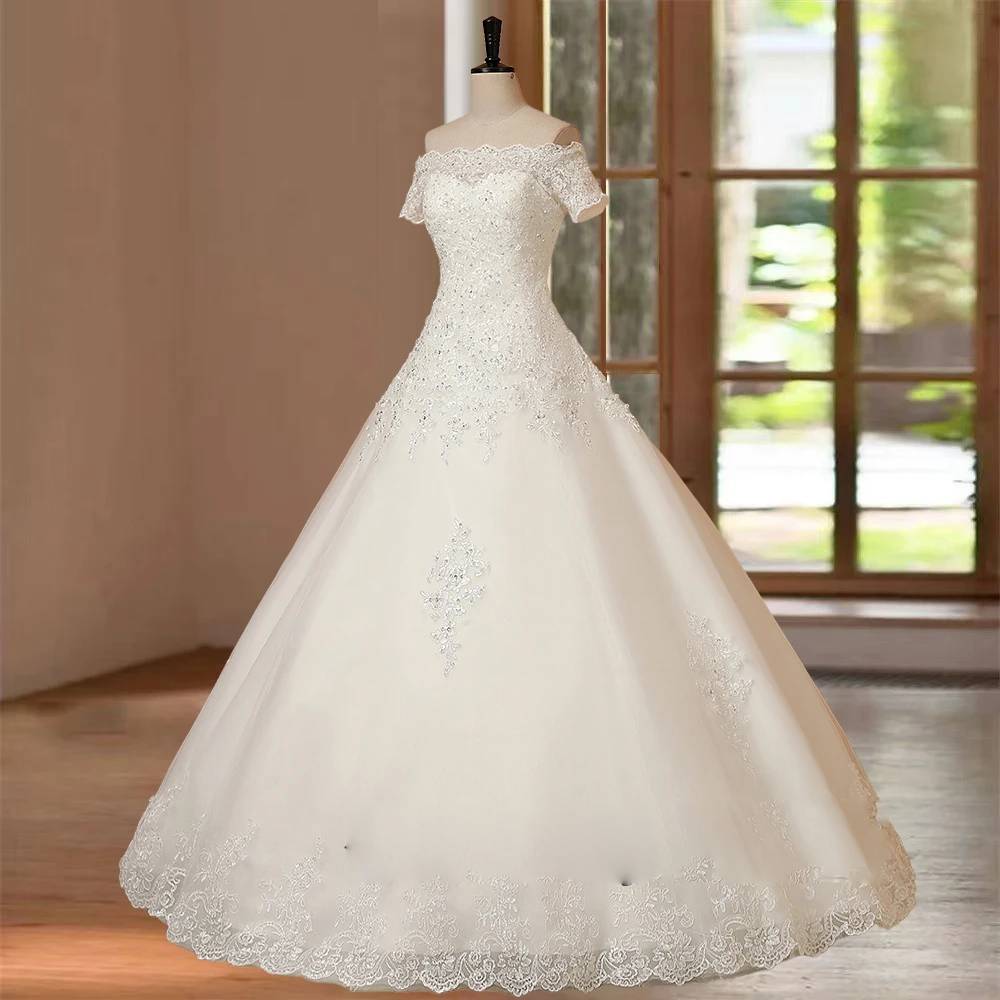 Three-quarter angle of a classic A-line bridal gown on a studio mannequin, emphasizing the voluminous tulle skirt, central lace applique, and structured bodice.