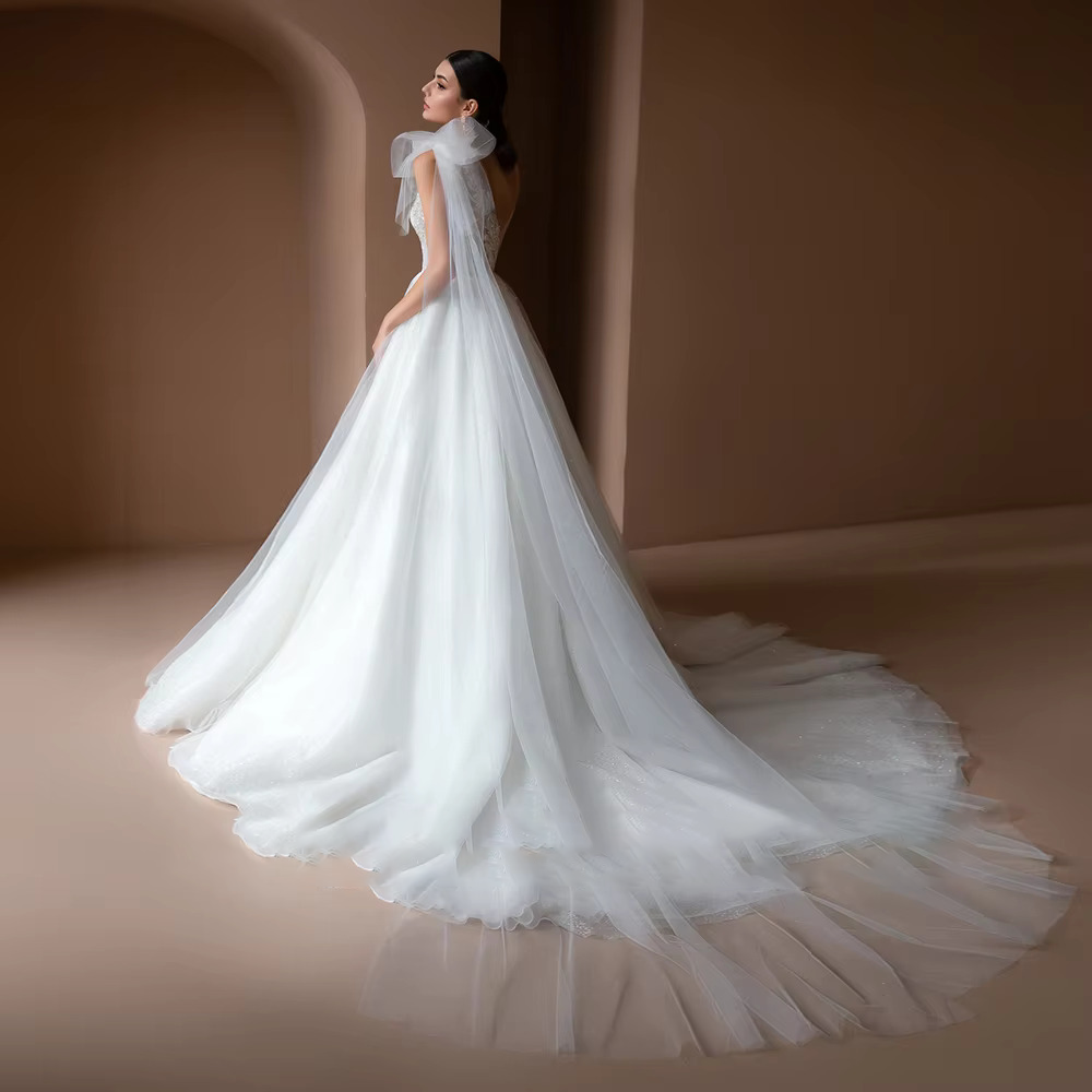 Detailed back view of the luxury off the shoulder bridal gown, showcasing an elegant low lace-up corset back design and a sweeping chapel-length train.
