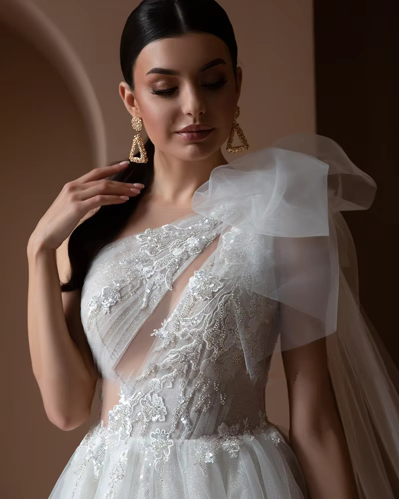 High-resolution studio shot of the off the shoulder bridal dress variation, showcased in a sophisticated warm champagne or light ivory tone variant.