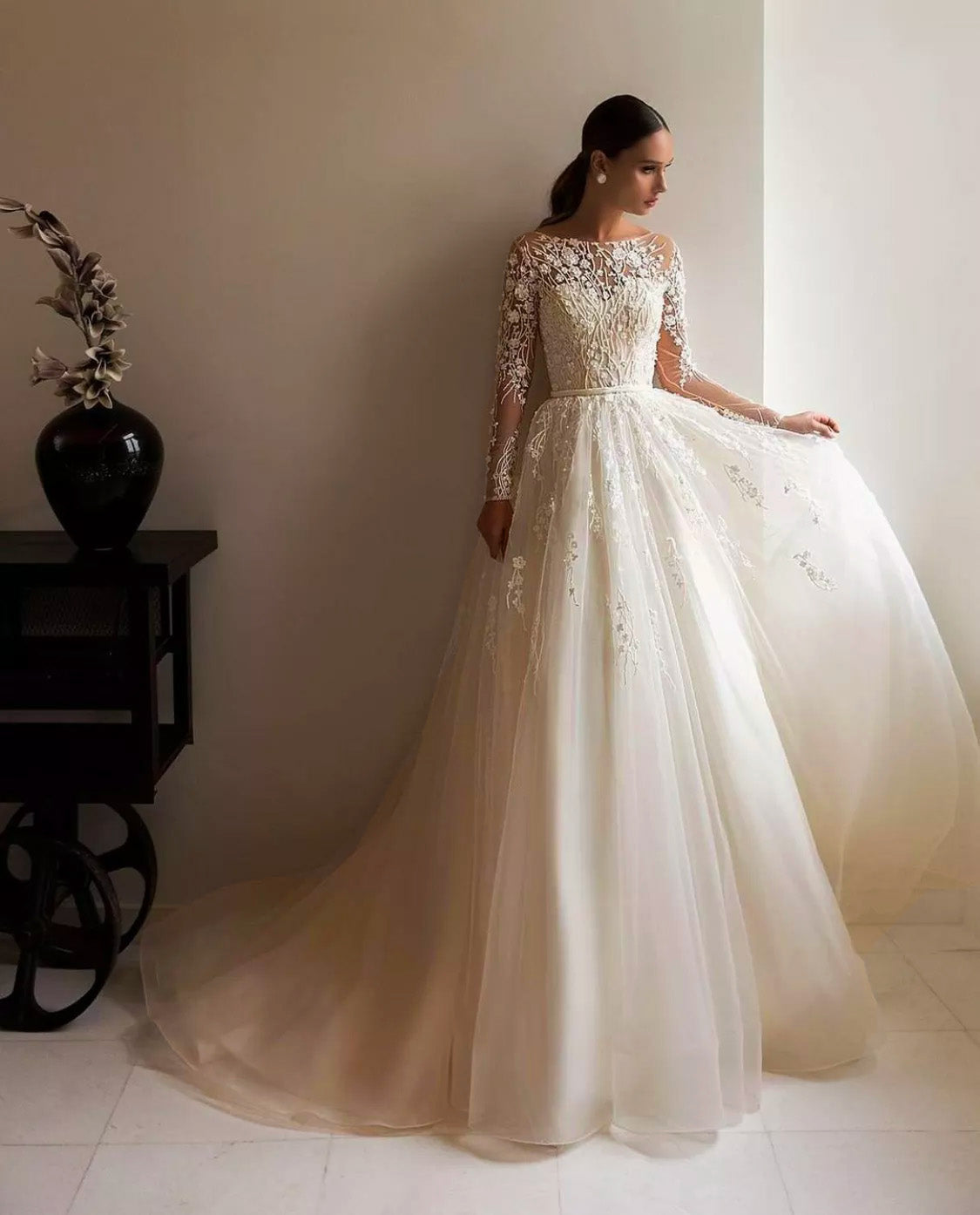 Full-body view of a long sleeve A-line wedding dress with a flattering silhouette and intricate tulle detailing.