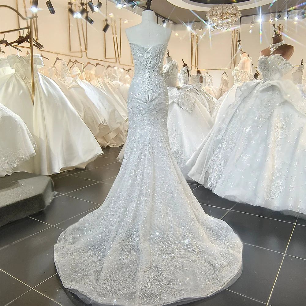 Close-up detail of the bridal gown's front bodice, focusing on the high-density sequin lace patterns, sweetheart neckline insert, and cape attachments.