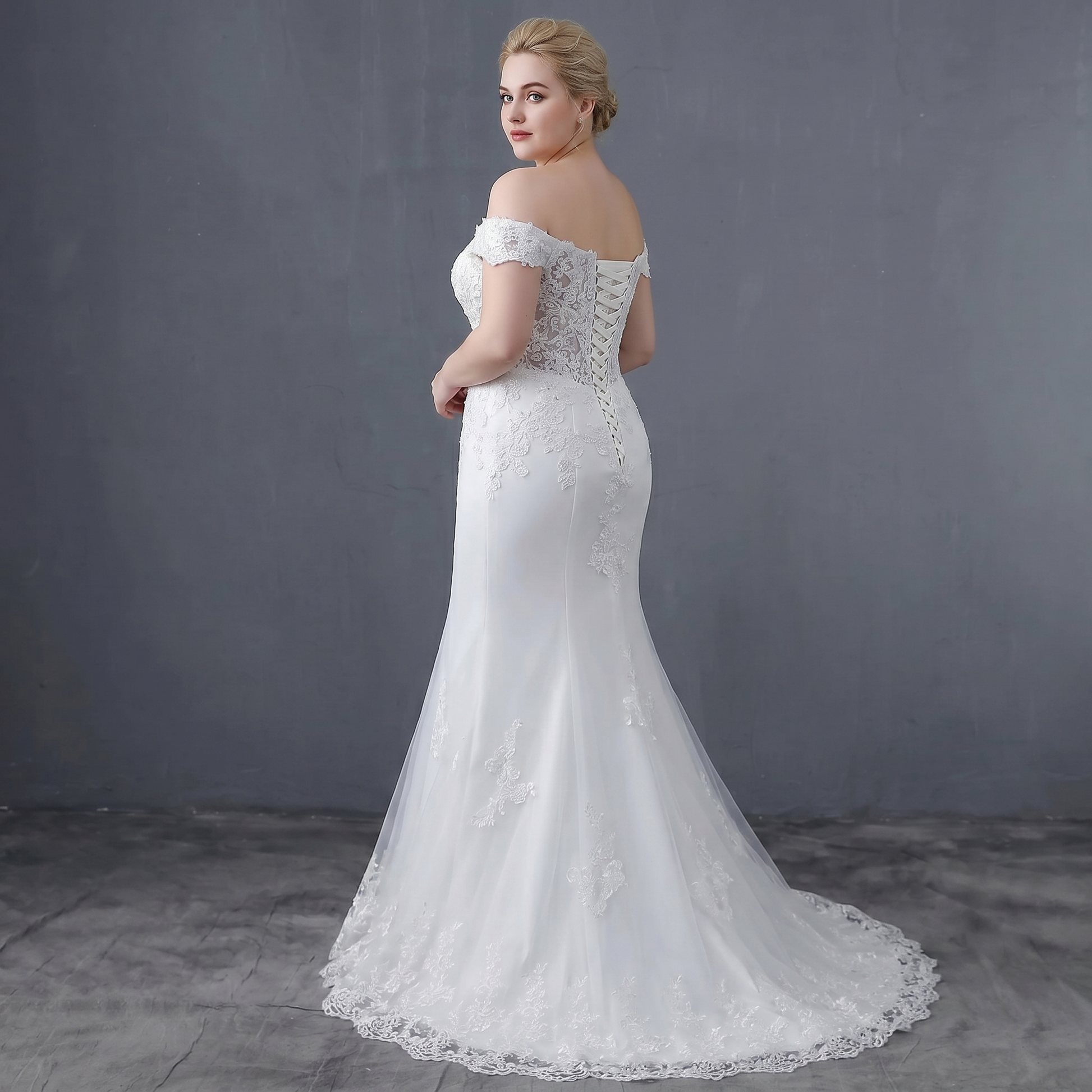 Rear view of the mermaid wedding dress featuring a lace-up corset back and sophisticated waist detailing, shown on a model.