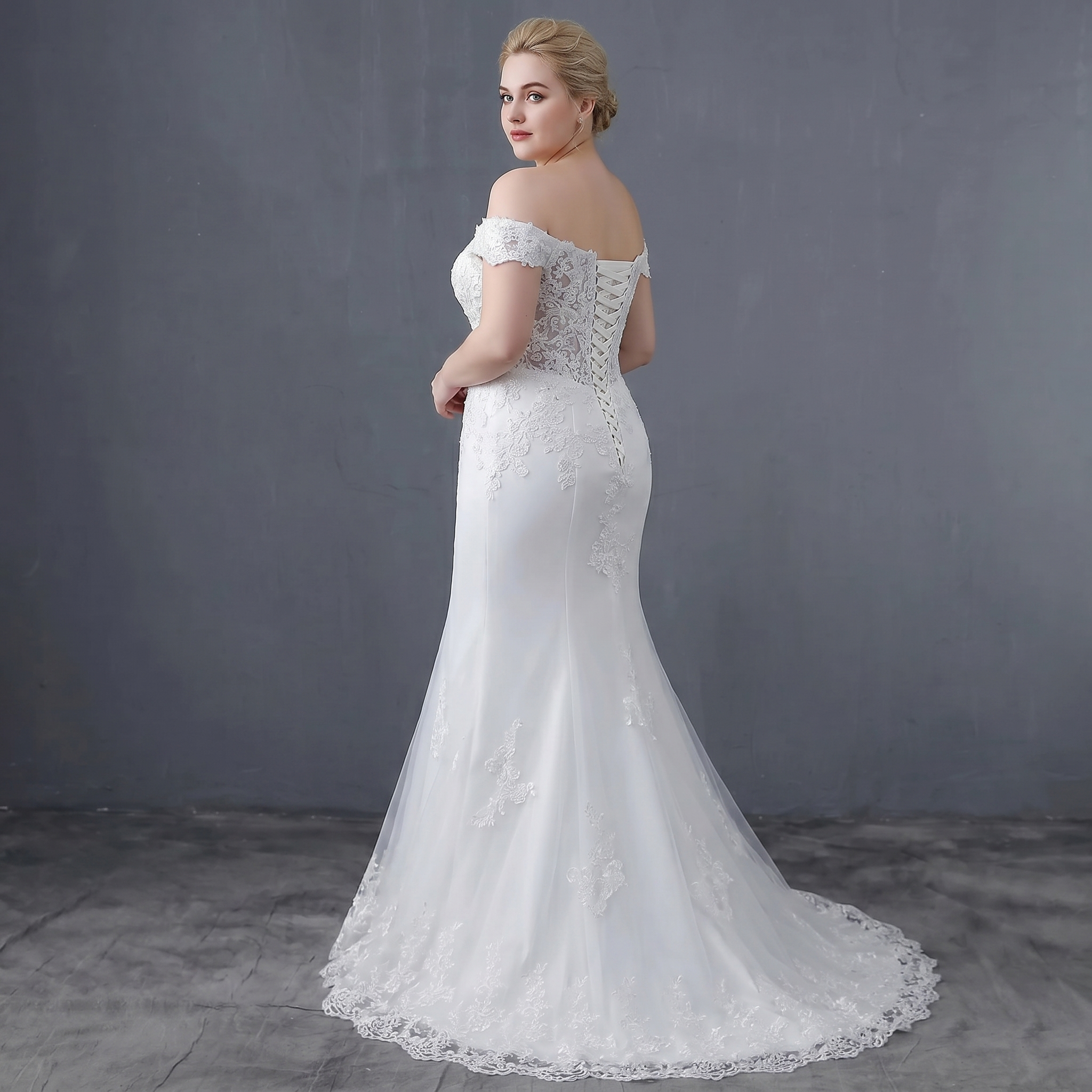 Rear view of the mermaid wedding dress featuring a lace-up corset back and sophisticated waist detailing, shown on a model.