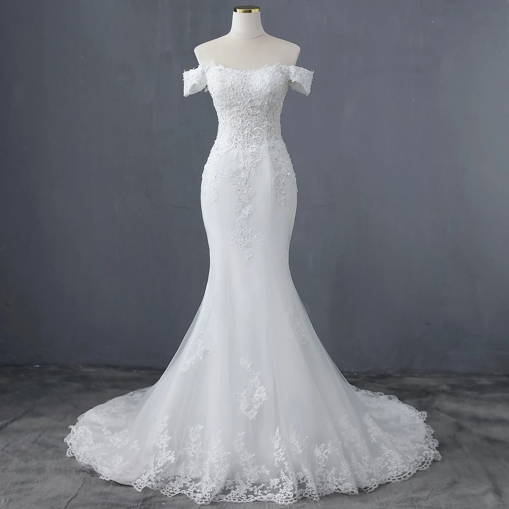 Full-body view of an elegant boat neck mermaid bridal gown on a mannequin, highlighting the fitted bodice and delicate lace overlay.