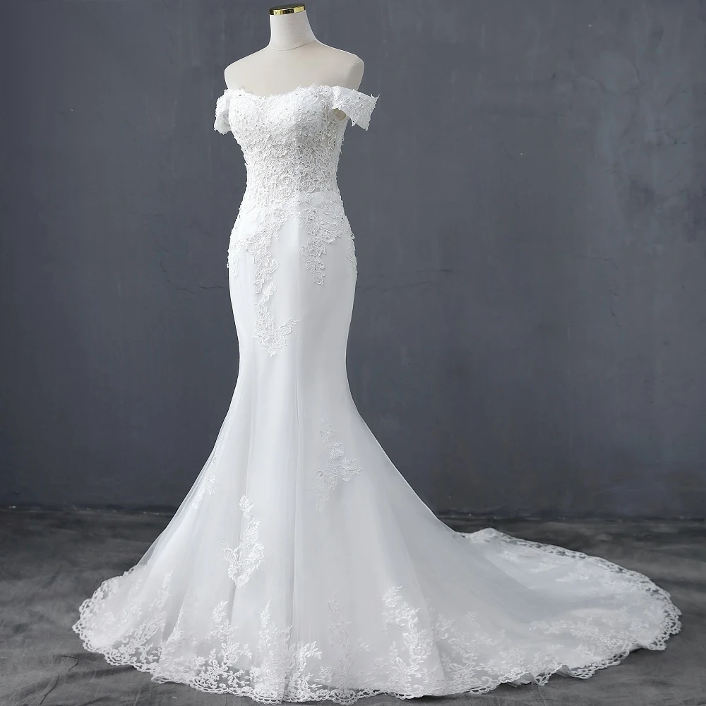 Front view of a sleek boat neck mermaid bridal gown on a mannequin, showcasing the flattering waistline and lace embroidery.