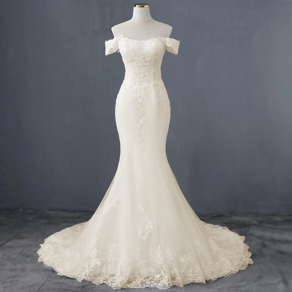 Close-up view of the elegant boat neck neckline and beaded lace bodice on the wedding dress.