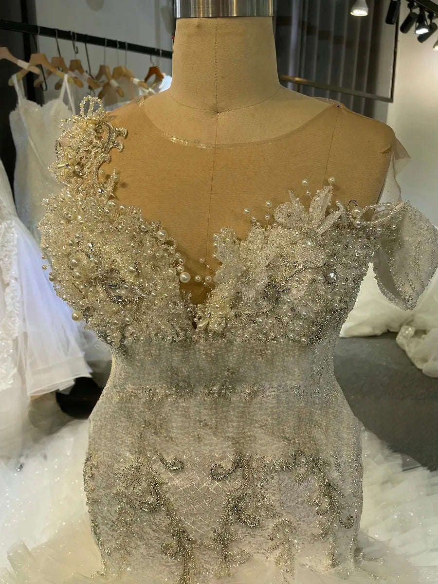 Close-up detail of the hand-beaded bodice on the African mermaid bridal gown, featuring elaborate pearl and crystal embroidery and an illusion plunging neckline.