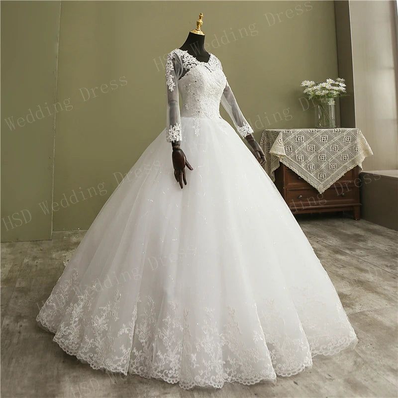 Mid-length back angle view highlighting the exquisite lace patterns trailing down the sheer illusion mesh back and along the waist of the vintage bridal gown.