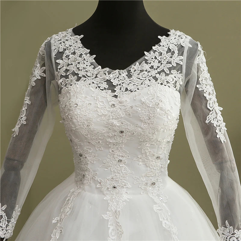 Full-length studio display of the elegant long sleeve V-neck lace ball gown wedding dress, featured in a timeless soft white color option.