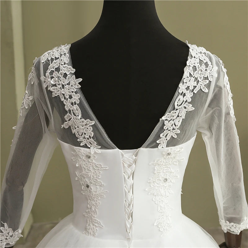 Front view of the vintage long sleeve lace ball gown bridal dress, rendered in a romantic soft blush pink color option for an alternative fairytale look.