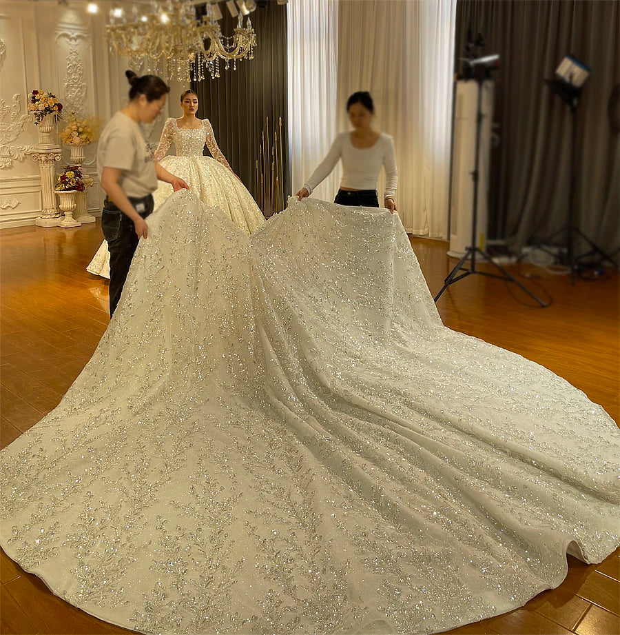 A demonstration of the massive scale and heavy silver embellishments of the detachable cathedral-length train for this dramatic bridal ball gown.