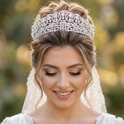 Close-up portrait of a bride wearing a luxury baroque crystal zircon bridal crown with an elegant updo hairstyle