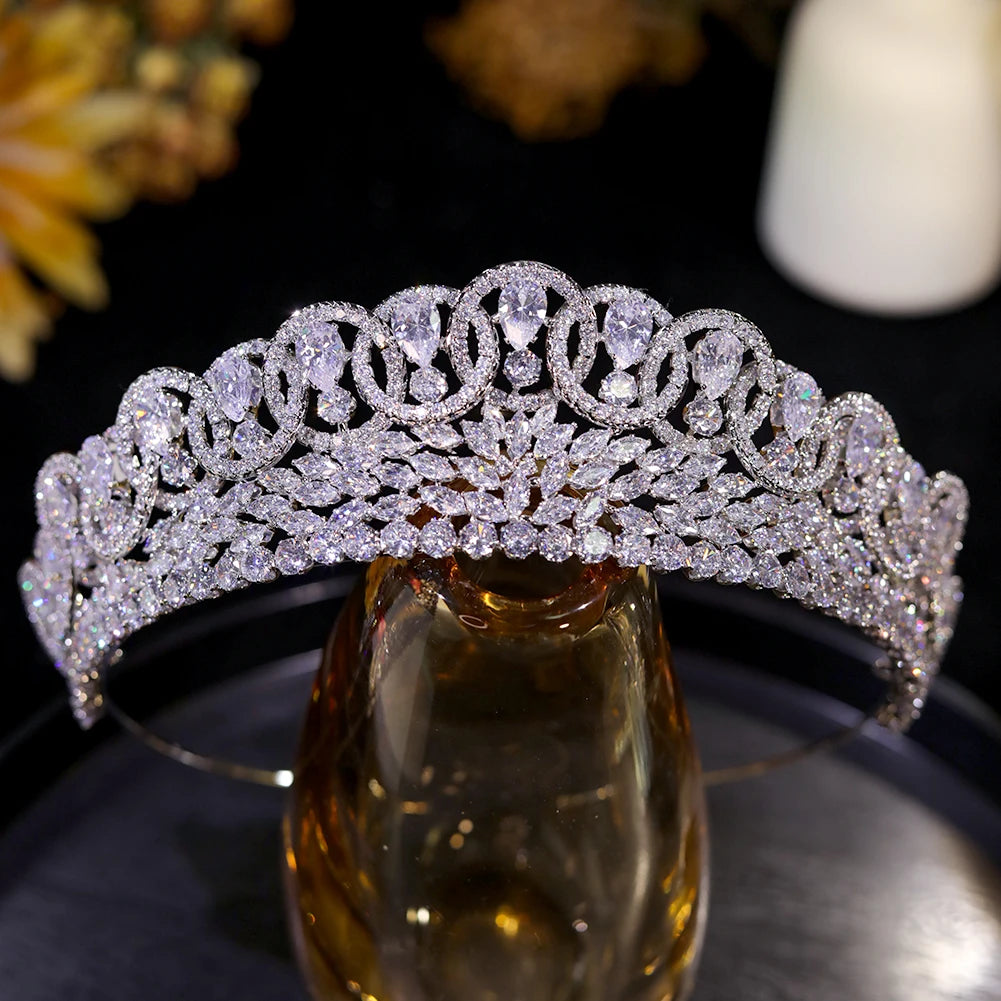 Front profile of a sparkling baroque crystal zircon wedding tiara on a luxury amber glass display stand