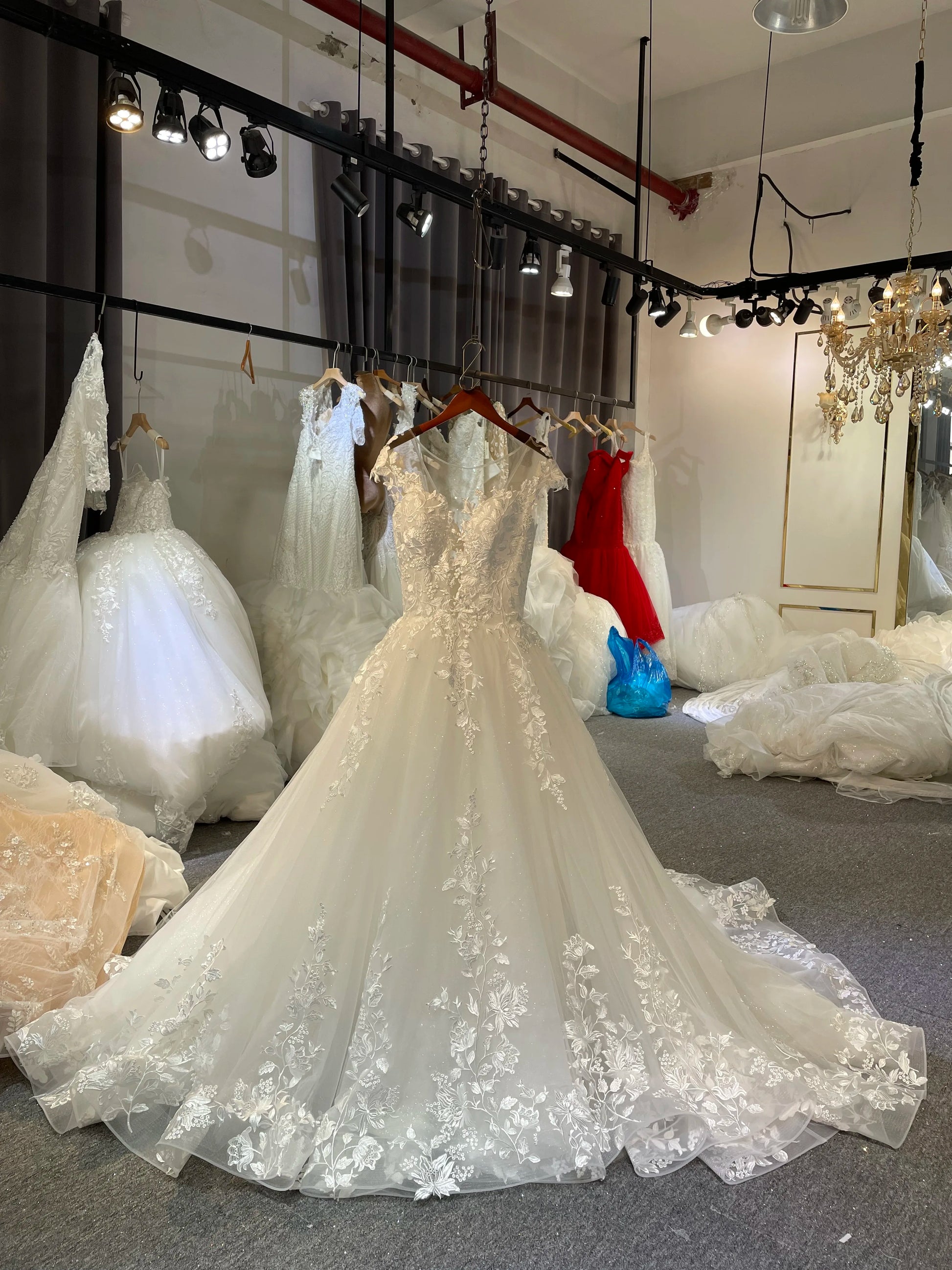Small A-line bridal dress on a hanger showcasing a sparkling glitter tulle skirt and a delicate lace-covered bodice for a romantic wedding.