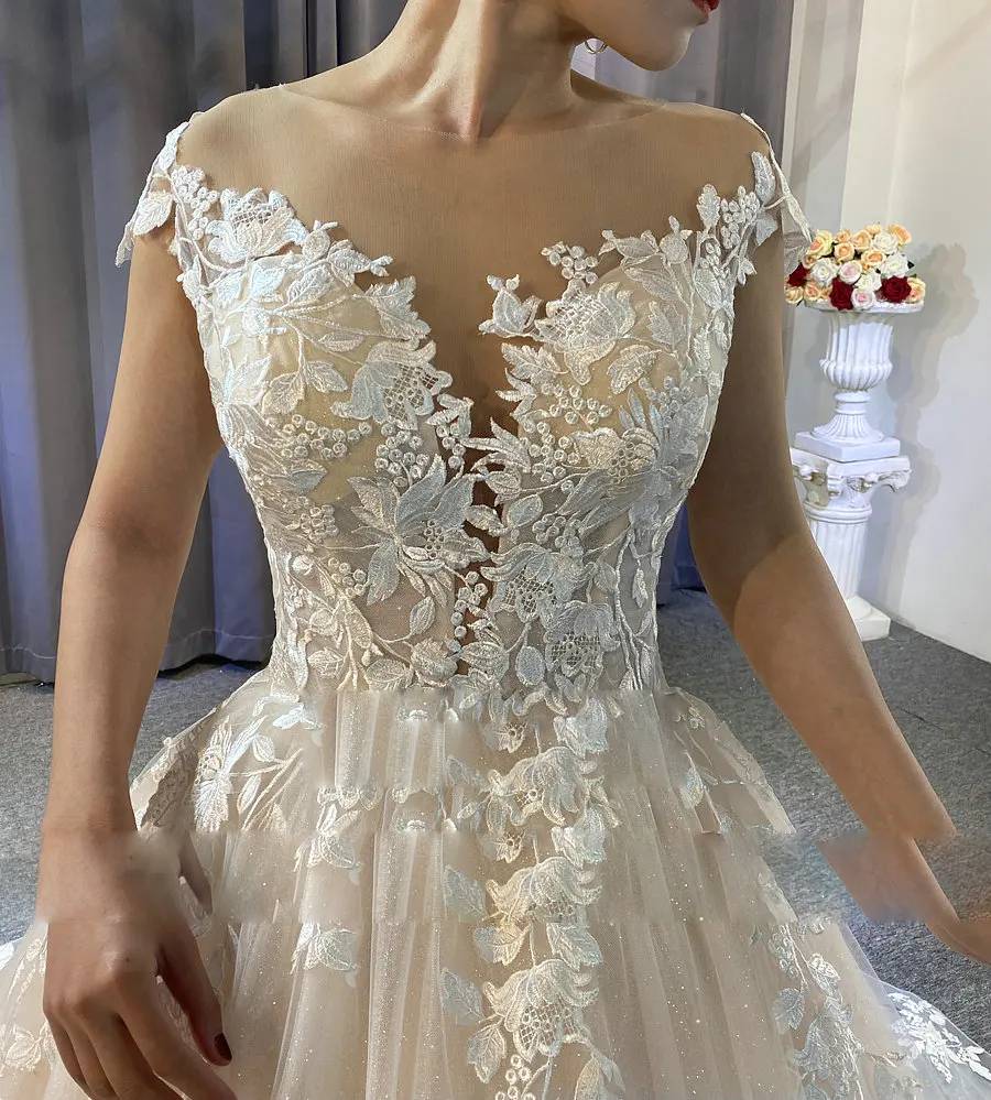Close-up of an illusion V-neckline on a bridal gown with intricate floral embroidery and shimmering sequin details for a sun-drenched celebration.