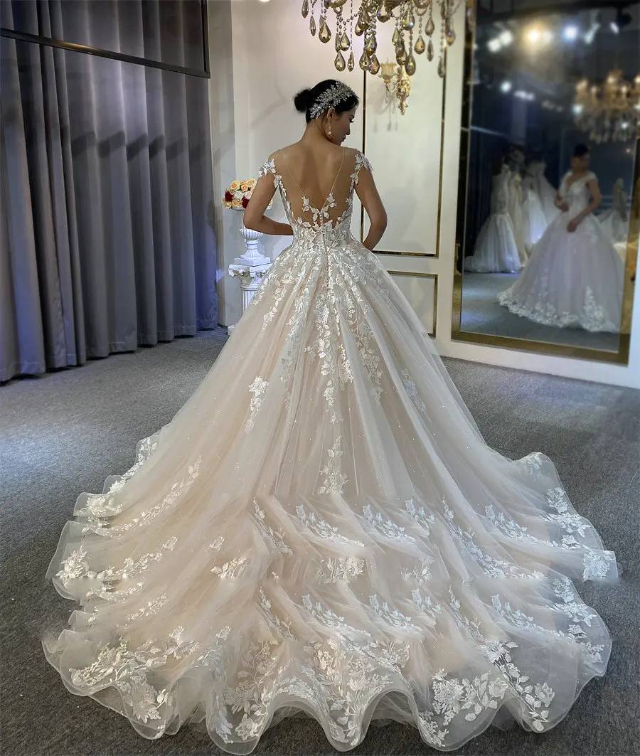 Romantic A-line wedding dress back view highlighting a scalloped lace hemline and a shimmering sweeping train perfect for a seaside ceremony.