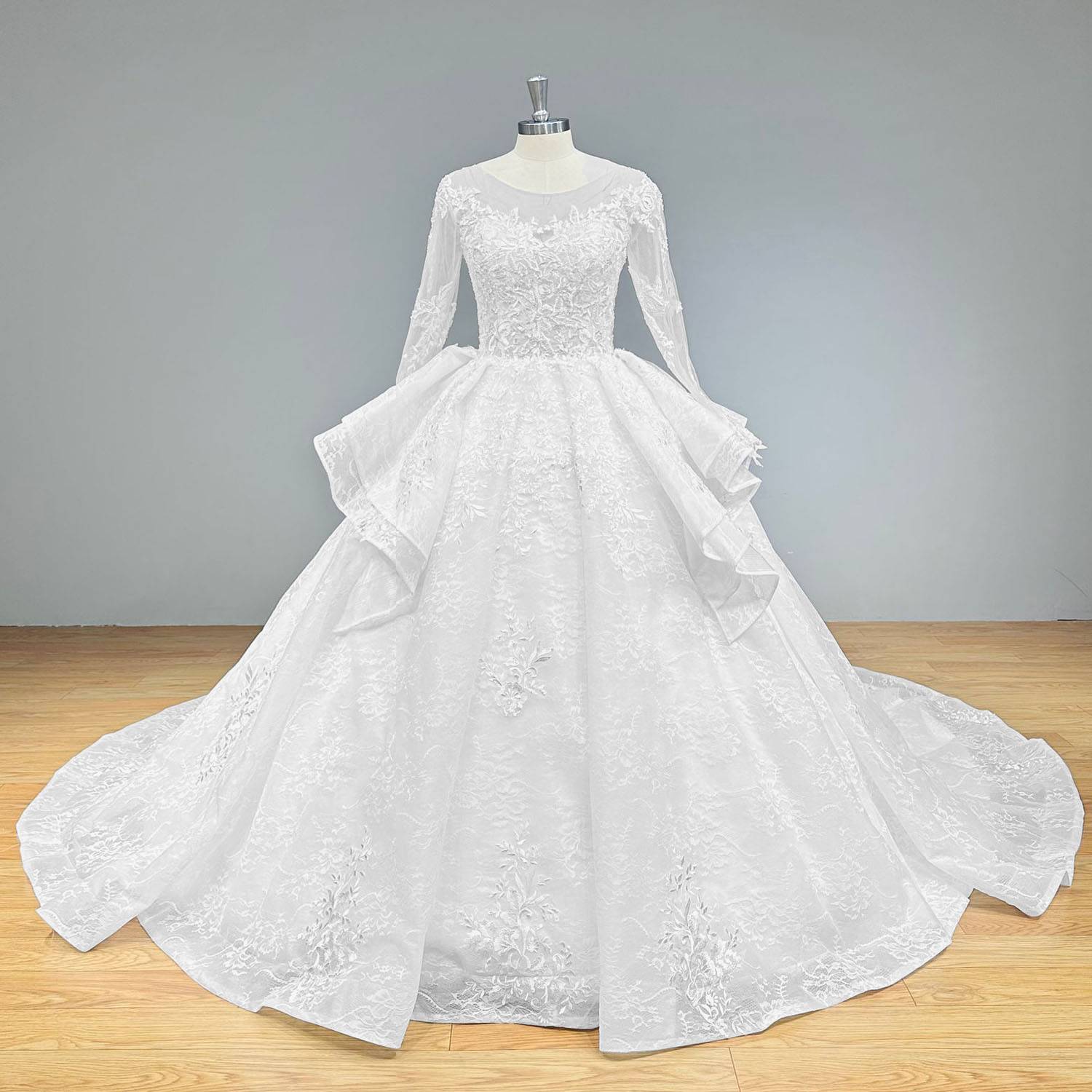 Front view of a long-sleeve beaded lace ball gown bridal dress featuring a scalloped illusion neck and full ruffled cathedral train.