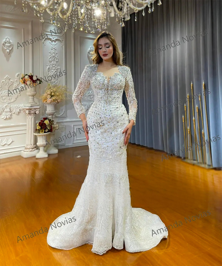 Elegant trumpet silhouette bridal gown with heavy crystal beading and sheer long sleeves, showcasing a form-fitting design without the detachable overskirt.