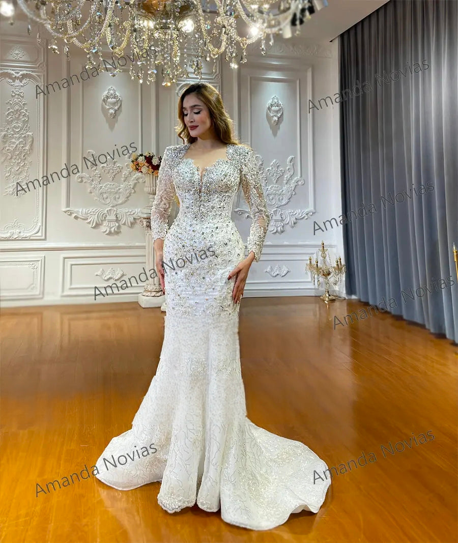 Full-length portrait of a long sleeve beaded bridal dress with a plunging neckline and floral lace embroidery in a high-end boutique setting.