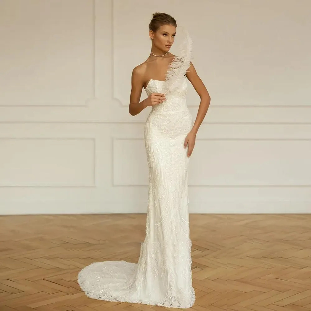 Glamorous strapless sequin mermaid wedding dress with a curved neckline, form-fitting embroidered bodice, and an elegant trailing trumpet skirt.