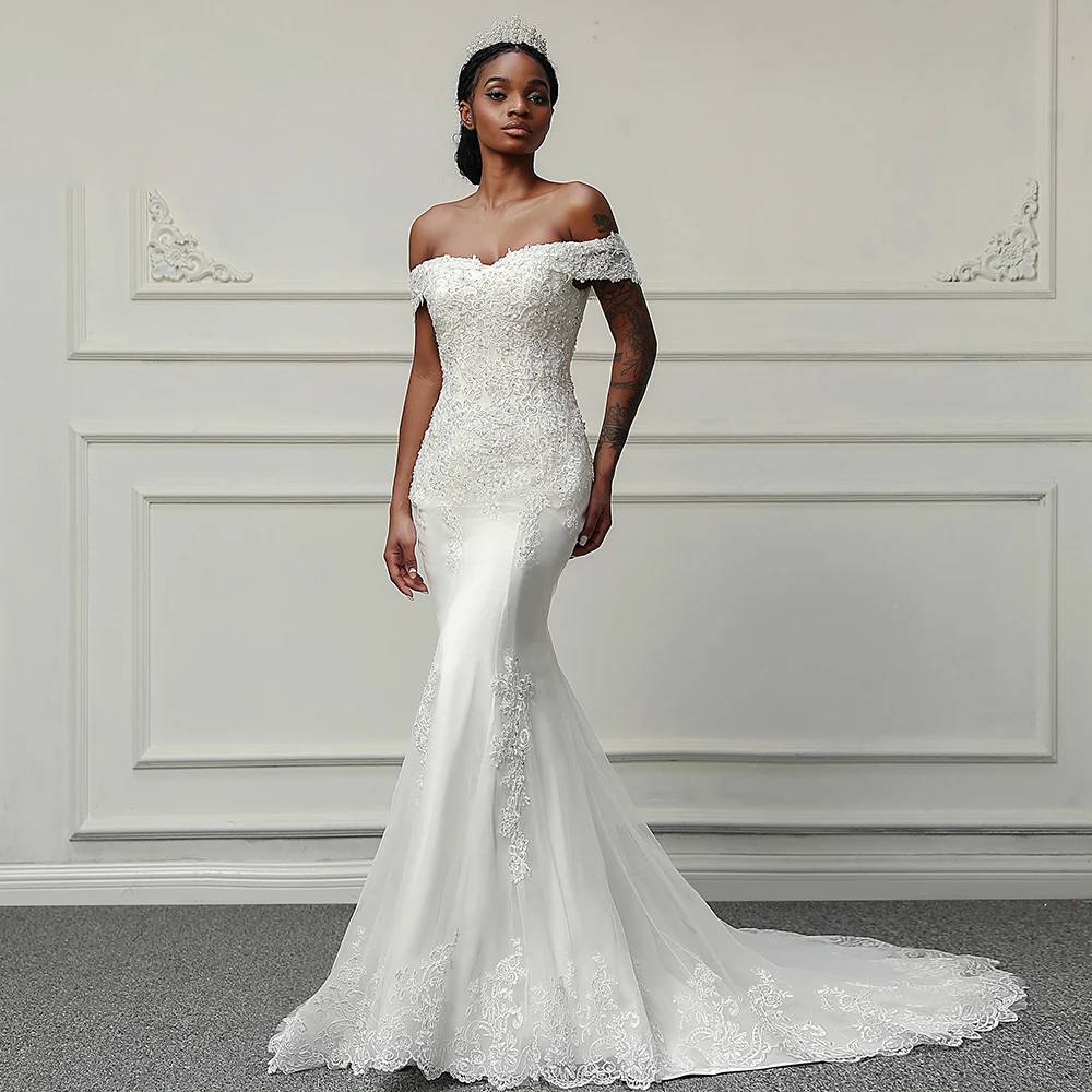 Elegant off-shoulder mermaid bridal gown featuring hand-beaded lace embroidery and a fitted silhouette on a bride wearing a tiara.